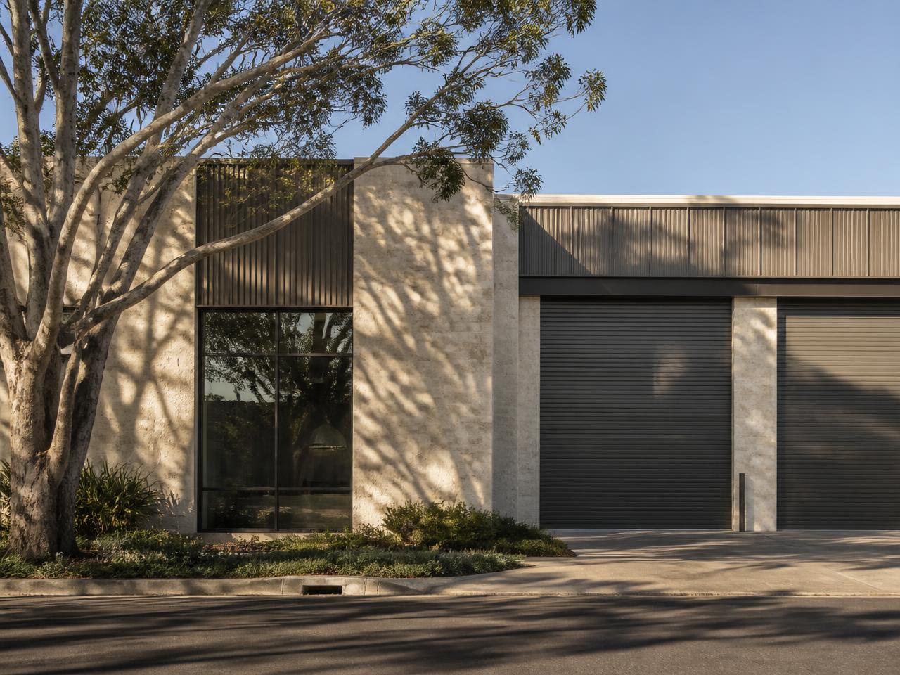 Timeless commercial warehouse facade with mature trees and warm afternoon light.