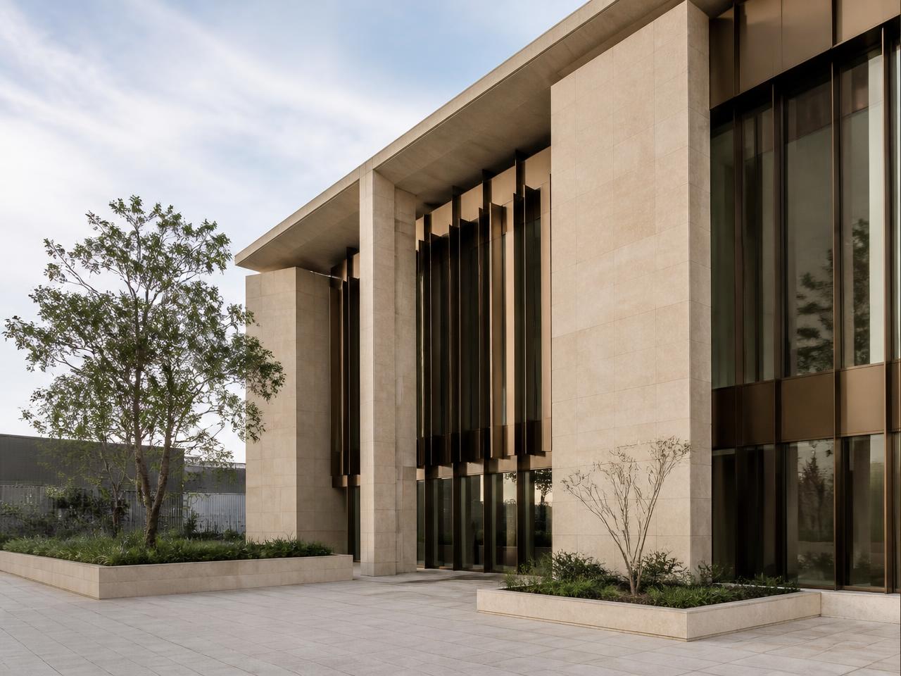 Modern commercial building facade with limestone and bronze metal detailing.